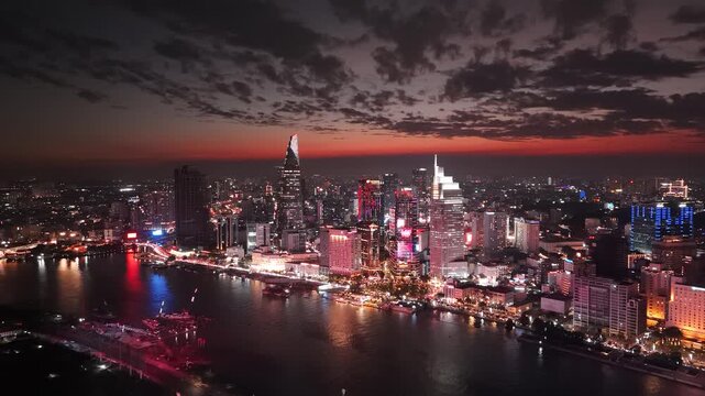 Ho Chi Minh City, Vietnam at night: 4K Aerial Night Drone Footage of Skyline, Skyscrapers, Bitexco Tower, Saigon River, illuminated Bason Bridge, Illuminated Streets, Busy Traffic in Evening