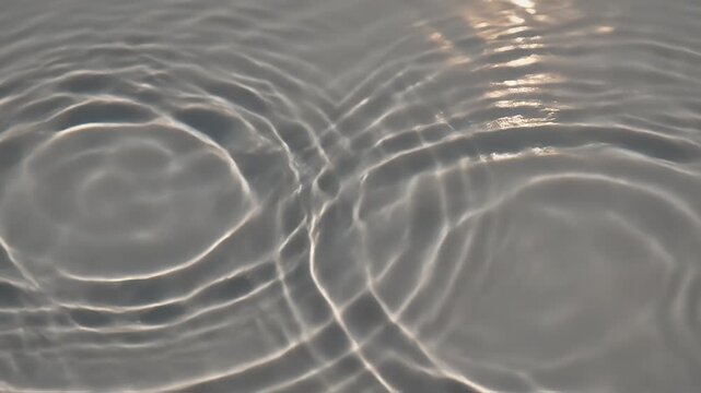Abstract image of water surface with ripples, light reflections, and gradient of white/gray tones