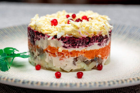 Traditional Russian layered "dressed herring" salad ("Selyodka Pod Shuboy"), close-up shot.