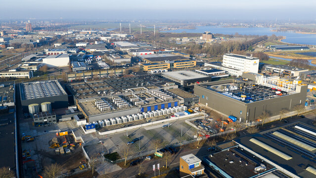 Utrecht, Netherlands - 24 January 2026: Aerial view of the Iron Mountain data center, a sprawling complex of industrial buildings reflecting the crisp winter light under a vast, open sky.