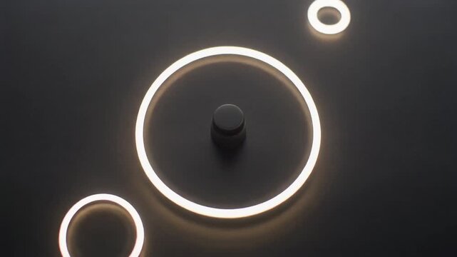A glowing circular light fixture on a dark surface with a small metallic ring beside it, possibly for interior design or technology advertising