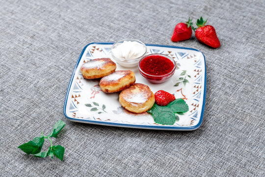 Traditional Russian Syrniki (Cottage Cheese Pancakes) with Sour Cream and Raspberry Jam