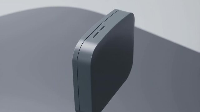 Close-up view of a sleek, modern digital device with rounded edges, displayed on a smooth surface, showcasing its minimalist design and subtle details