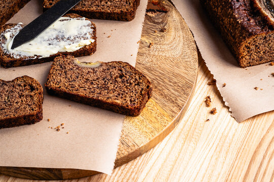 Slices of banana bread with butter on cutting board