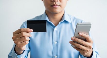 Man holding credit card and smartphone for online shopping.
