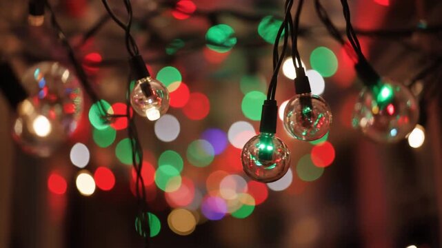Colorful string lights hanging with blurry background lights, festive holiday decoration for celebration