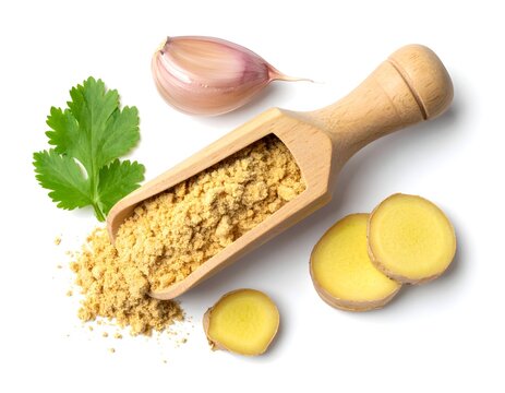 Wooden scoop of ginger powder with sliced garlic clove on white background