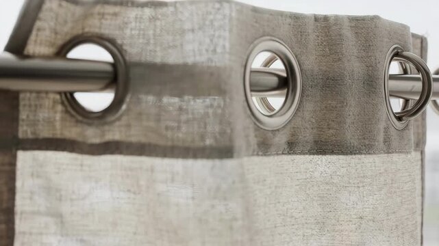 Medium shot showcasing eyelet curtain header style highlighting metal rings threading smoothly over the rod for modern and easy hanging system construction.
