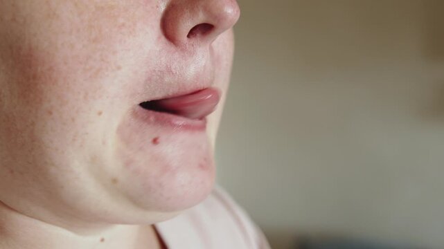 Overweight woman licking lips with moist smacking sounds. Close-up of mouth of plus size person performing articulation gymnastics to improve mobility of speech apparatus.