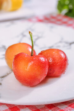 Fresh Golden Yellow Rainier Cherries with Water Drops on White Plate - Premium Imported Fruit
