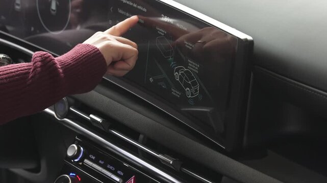 manos de una mujer moviendo los controles de un auto nuevo para configurarlo