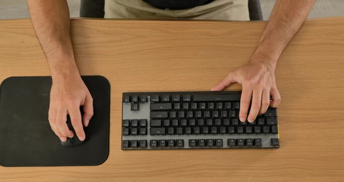Close-up of man using wireless mouse and mechanical keyboard on desk