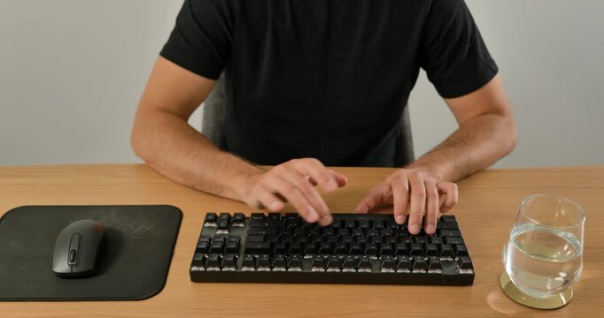 Close-up of man using wireless mouse and mechanical keyboard on desk