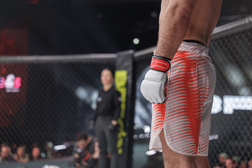 MMA fighter awaiting referee signal inside professional combat sports cage