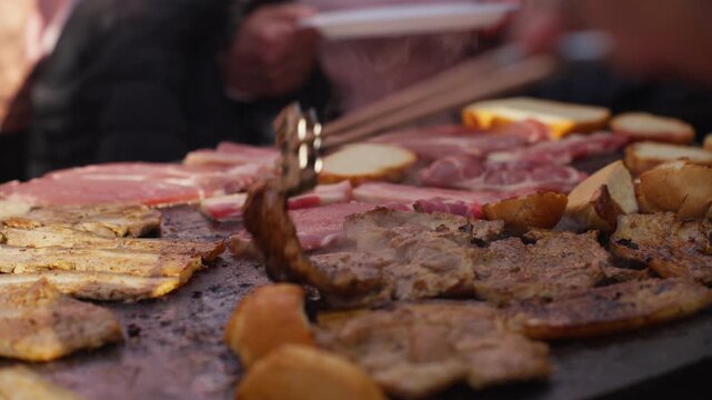 Close-up view of meat cooking on hot grill with visible steam and oil. Focus on textures, heat, and cooking process rather than people.