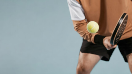 Close-up action shot of a pickleball player in motion with paddle and ball