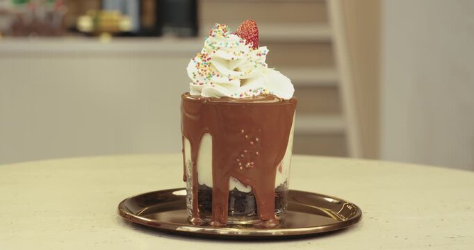 Sweet chocolate trifle decorated with whipped cream, sprinkles, and a strawberry