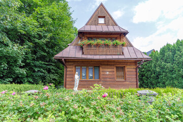 Traditional wooden house with Mary statue in Poland