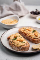Delicious sandwiches with hummus and ingredients on white table, flat lay. High quality photo