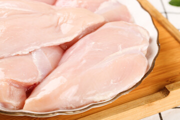 Fresh Raw Chicken Breast Fillets Sliced in Glass Dish on Wooden Board Ready for Cooking