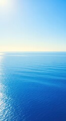 Obraz premium Expansive blue ocean surface stretching to the distant bright horizon under a calm sunny sky, emphasizing peaceful natural seascape, tranquil, natural, beautiful