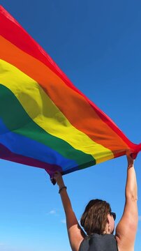 Gay pride parade, woman woman holding flag with rainbow lgbt flags