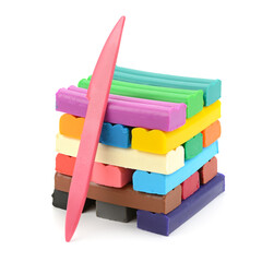 Vibrant stack of multicolored modeling clay bars in rainbow hues including red orange yellow green blue purple pink brown black with pink plastic sculpting tool leaning on isolated white background