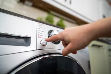 Washing machine. Pressing start button on modern washing machine display. Daily chores
