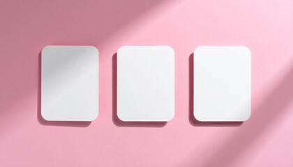 Top-down shot of three blank rounded-corner cards on pink surface, isolated mock-up, minimal