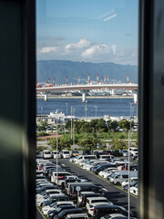 Fototapeta premium Kobe Harbor View with Parked Cars and Industrial Bridge