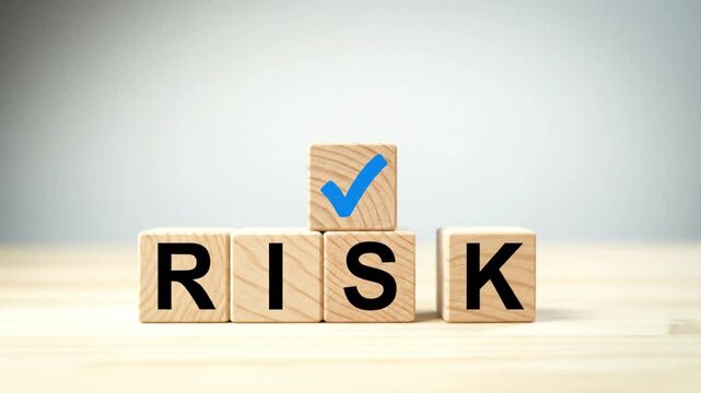 Wooden blocks spelling out risk on a table