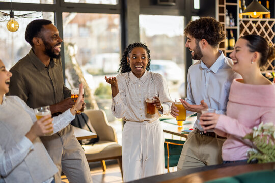 Diverse group of friends enjoying beer and conversation at a pub bar counter, highlighting social interaction, friendship, and lively casual atmosphere.