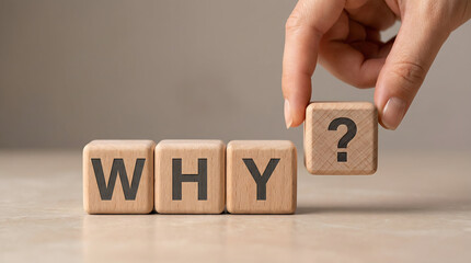 Naklejka premium Questioning Concept with Hand Placing Wooden Block with Question Mark to Spell WHY