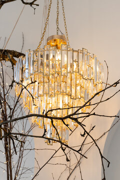 The design lamp chandelier on the roof of house near window.Expensive interior. Large electric chandelier made of transparent glass beads. Luxury old vintage chrystal chandelier