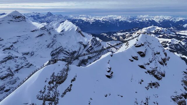 Aerial video from a scenic flight over Glacier 3000 Paradise in Switzerland, showcasing icy peaks, dramatic alpine landscapes, and breathtaking mountain scenery