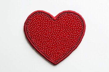 Fototapeta premium Red heart patch embroidered with red beads on a white background.