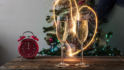 New year celebration with champagne, sparkler heart, and alarm clock