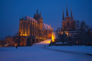 Obraz premium cathedral square in Erfurt with view to snow covered cathedral and church Severi at a winter day in the blue hour