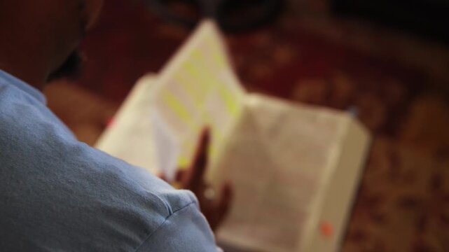 African man reading and studying the holy bible at home