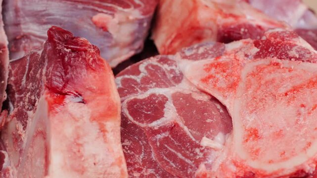 Fresh beef ossobuco steak with salt, spices and herbs on textured background, bones. 