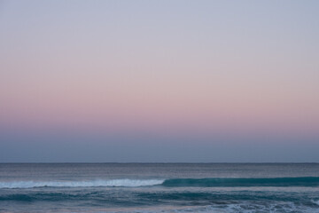 Fototapeta premium Soft pastel dawn sky over calm ocean waves