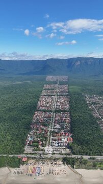 Vis&atilde;o a&eacute;rea em v&iacute;deo drone 4K do maior condom&iacute;nio residencial do litoral paulista, localizado &agrave; beira da Praia de Boraceia, em Bertioga, destacando a extensa &aacute;rea urbana integrada ao mar.