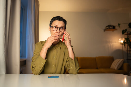Nervous senior woman talking with scammers on smartphone, phone thefts misleading elderly person with tricks and manipulation, trying to get personal data and financial information from mature female.
