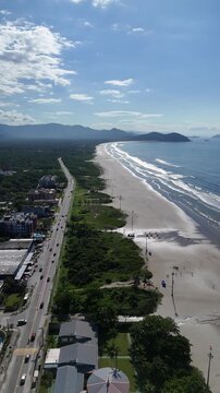 Imagem a&eacute;rea vertical da Praia de Boraceia evidenciando a orla mar&iacute;tima, a vegeta&ccedil;&atilde;o costeira e o alinhamento das resid&ecirc;ncias ao longo do litoral norte de S&atilde;o Paulo.