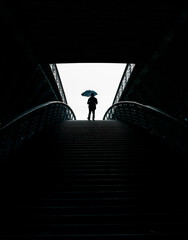 man with umbrella in a dark tunnel