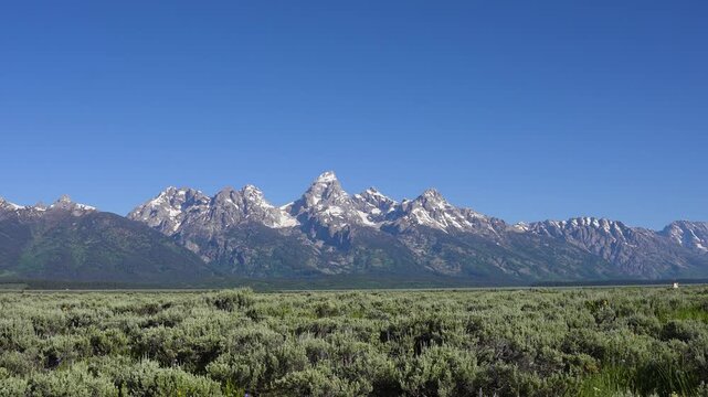 Slow zoom out shot revealing an amazing landscape of the Grand Teton Mountains, showcasing rugged peaks, vast open scenery, and dramatic natural beauty in Grand Teton National Park, Wyoming