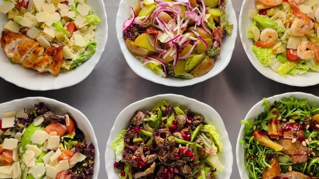 Rows Of Assorted Salad Bowls Set For Catering, Vibrant Toppings, Shaved Cheese, Shrimp And Grilled Chicken Options, Overhead Pattern, Event Food Taken on mobile device.