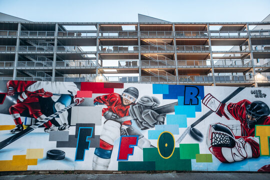 Milan, Italy - May 23, 2025: Street art murals painted on a construction site fence in the Lambrate district, with modern residential buildings under development in the background