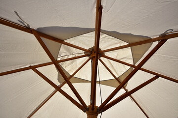 Large sun umbrella with wooden frame canvas top and rope controls. Location: Auckland New Zealand