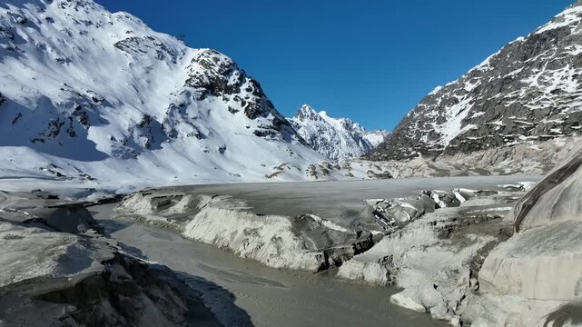 Aerial view of glacial river flowing through melting ce valley